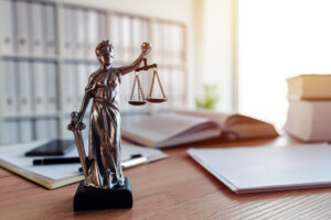 Lady Justice statue in law firm attorney office, blindfolded Justitia with balance scales and sword is personification of moral force in judicial system